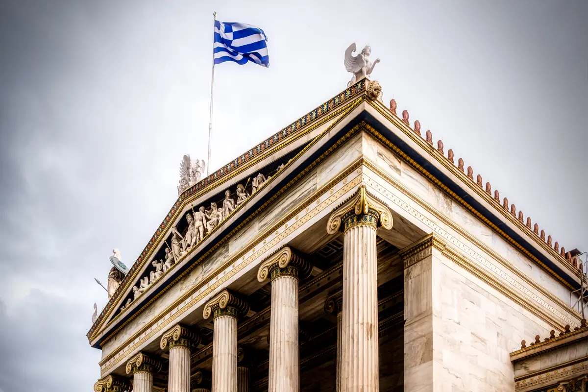 Die prächtige Nationale Akademie von Athen erhebt sich majestätisch vor einem bewölkten Himmel